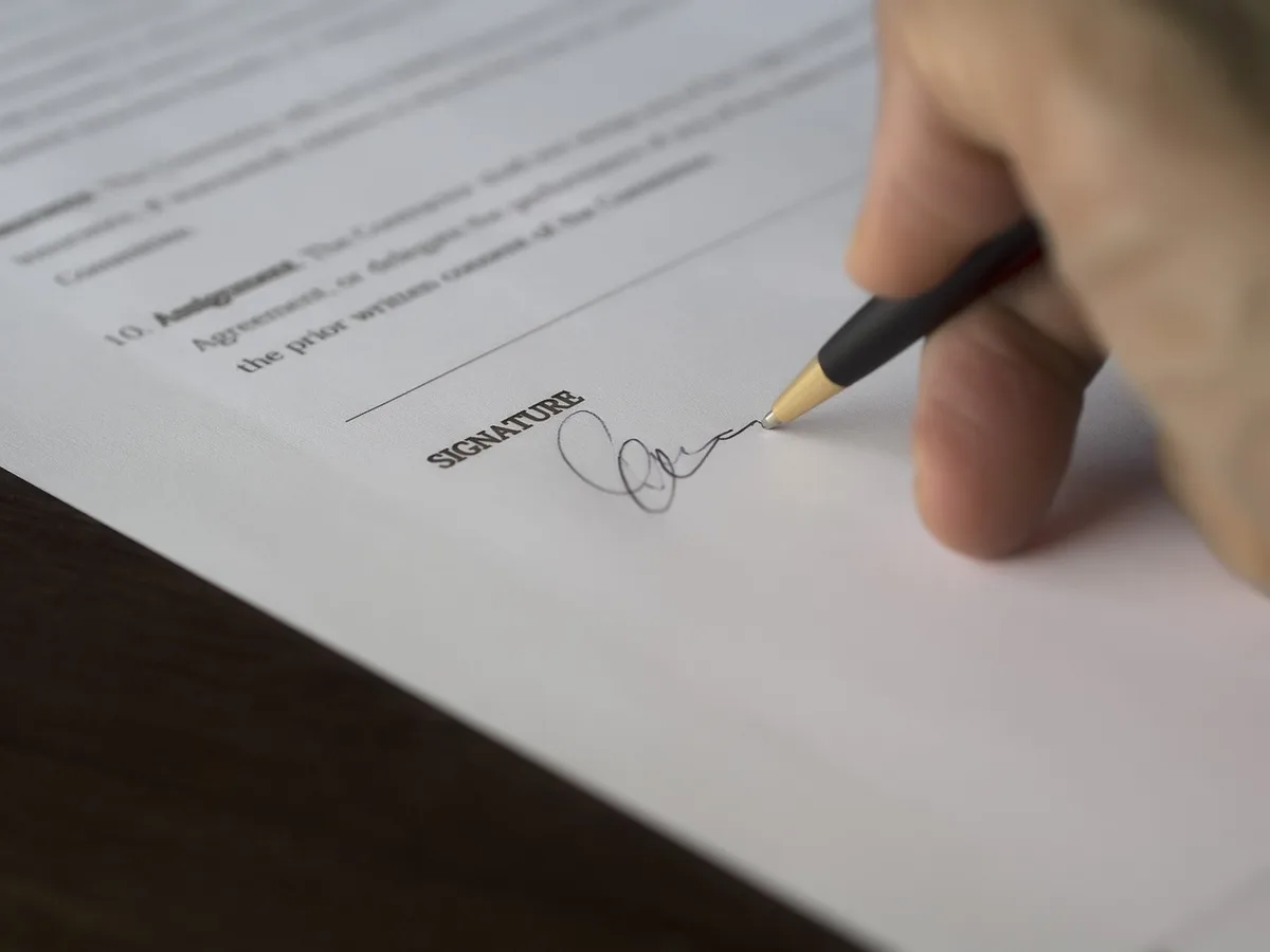 Signature de statuts avec clés de maison symbolisant formalités avant location